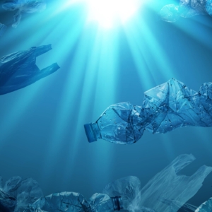 pet-plastic-bottles-single-use-plastic-bags-floating-sea-ocean-with-rays-sunlight-min